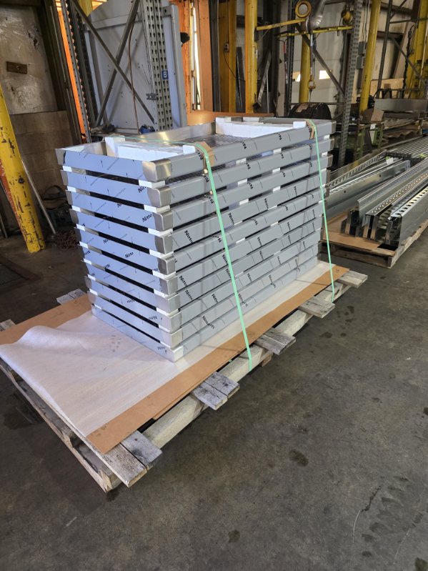 MLC Manufacturing — stacked aluminum formed parts on pallet